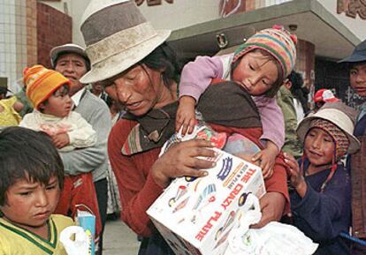 Una mujer de Potosí acarrea una caja de juguetes regalada por el Gobierno boliviano.