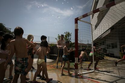 Alumnos de la escuela Fort Pienc de Barcelona jugaban el viernes con agua en el patio.