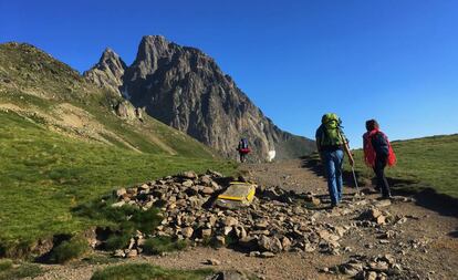 Excursionistas en el collado de Soum de Pombie con la cara sur del Midi d’Ossau al fondo, en el Pirineo francés.