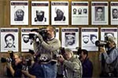 Cámaras y fotógrafos enfocan al presidente Bush en el cuartel general del FBI, mientras presentaba la lista de los terroristas de Al Qaeda más buscados, que aparecen en el cartel.
