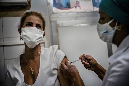Una enfermera aplica la vacuna Soberana 2 a una trabajadora de Salud, en el policlínico Héroes del Corinthia en La Habana, Cuba, 24 de marzo de 2021.