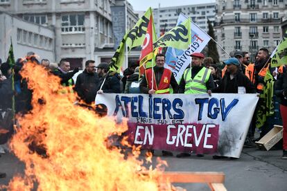 Transport workers hold a banner that reads, 'Workshop TGV Paris South East on Strike' during a protest called by French trade unions in outside the Gare de Lyon, in Paris on January 19, 2023.