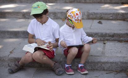 Dos niños leen durante la pasada Feria del Libro de Madrid.