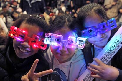 Un grupo de niñas con gafas esperan la llegada de 2018 en Hong Kong (China).