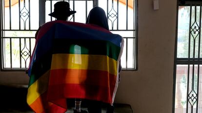 Una pareja gay de Uganda se cubre con una bandera LGTBI en marzo de 2023.