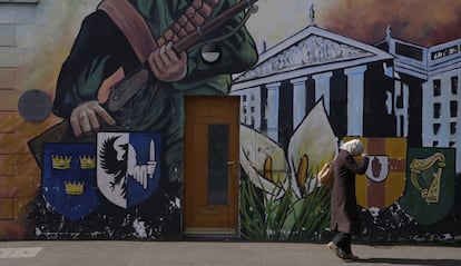No fue hasta el 10 de abril de 1998 que protestantes y católicos compartirían el poder tras la firma del Acuerdo de Viernes Santo, firmado por los Gobiernos británico e irlandés. No obstante, la violencia no cesó por completo. En la imagen, una mujer se ajusta el hijab mientras camina frente a un mural nacionalista en la calle Falls Road, en Belfast.