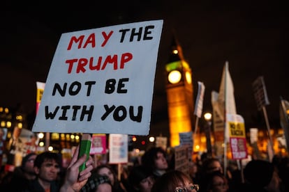 Manifestantes levantan una pancarta anti-Trump durante la manifestación frente al parlamento, aprovechando la futura visita del presidente estadounidense. 