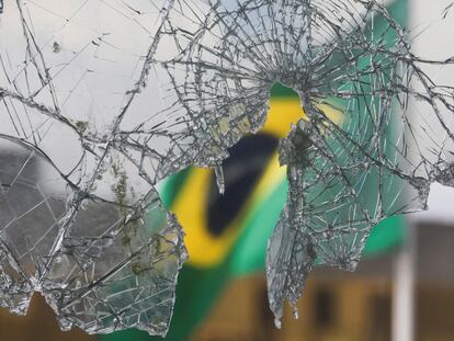 Una bandera brasileña se ve a través de vidrios rotos luego de los disturbios en el Palacio Planalto, en Brasilia, Brasil, el 10 de enero de 2023.