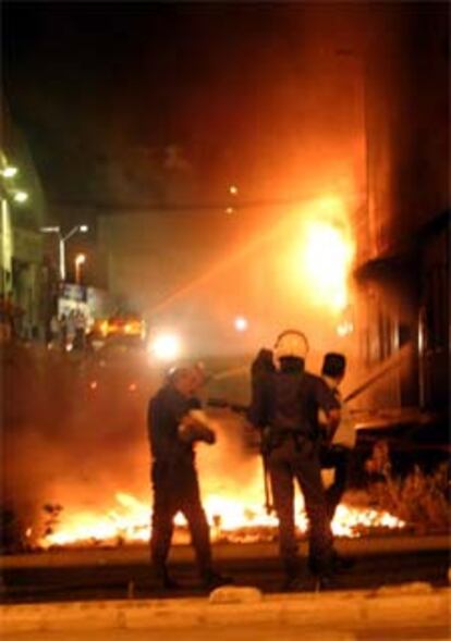 Policías antidisturbios vigilan la zona donde se produjeron los incidentes.