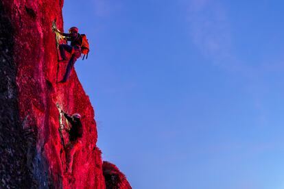 El técnico deportivo de escalada Roberto Álvarez (arriba) y una aficionada suben por la vía ferrata de Los Llanos (Camaleño), que el municipio ilumina por la noche con luces led de colores para potenciar esta actividad a todas horas.