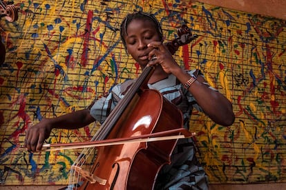 Sadia, de 16 años, empezó tocando el ukulélé, luego el violín y ahora el chelo. Resulta muy excepcional encontrar un chelo en Burkina, como pasa con el violín. “En nuestra orquesta, nueve niños y niñas entre 12 y 16 años han aprendido a tocar el chelo y esto enriquece los sonidos del violín, el ukulele, la guitarra, el bajo, la percusión africana y el balafón", explica Behrens. Actualmente, hay 6 alumnos y alumnas de violonchelo en tres niveles diferentes. La alumna más experimentada, Amsétou, da clases a los que empiezan.  
 
Uno de los grandes retos de la escuela es la conservación y mantenimiento de los instrumentos. El clima de Burkina Faso se caracteriza por dos estaciones, una seca en la que se pueden alcanzar temperaturas de hasta 47 grados, y otra húmeda, con abundantes lluvias durante meses, que provocan a menudo inundaciones. Durante la época seca, además, sopla el harmattan, viento del Sahara que transporta arena del desierto. Estos cambios extremos de temperatura afectan a los instrumentos de madera, la humedad tiene efectos negativos en las piezas de cuero y la arena del desierto se introduce en el mecanismo de los pianos eléctricos, produciendo daños. 
