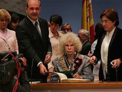 La duquesa de Alba firma en el libro de honor de la Junta ante la presencia de Chaves. A la izquierda, Soledad Becerril.