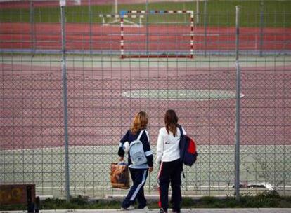 Dos chicas observan la portería en la que murió de un golpe en la cabeza el joven de Alcorcón.