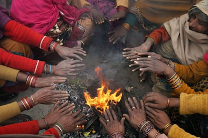 Pasajeros indios se calientan las manos alrededor de una fogata mientras esperan la llegada de su tren en Allahabad, India. En los últimos días una ola de frío ha asolado el norte de India.