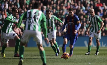Lionel Messi, del Barcelona, flanqueado por los jugadores del Betis.