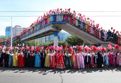 Los norcoreanos agitan ramos y banderas mientras miran el desfile de automóviles del líder norcoreano Kim Jong-un y del presidente surcoreano Moon Jae-in. 