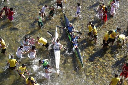 Momentos previos a la salida, en la que los tritones sacan del agua a los que no van a competir y los deportistas todavía están entrenando antes de que tengan que meter sus palas en los cepos, que les impedirá moverlas hasta que no se dé el cañonazo de salida.