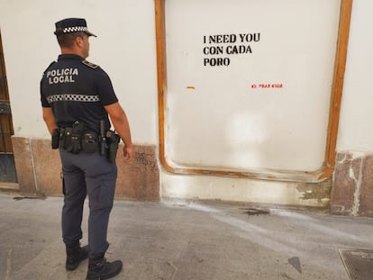 El agente que ha dado con la identidad de la grafitera, junto a una de las pintadas ya borradas de las calles de El Puerto.