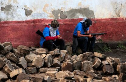 Dois membros de grupos armados que apoiam ao governo descansam em uma barricada depois dos confrontos com os manifestantes de Monimbó, em Masaya (Nicarágua), no dia 17 de julho de 2018.