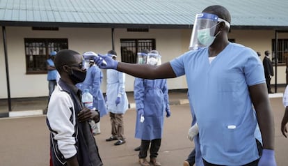 Un sanitario toma la temperatura a un ciudadano de Burundi en el campo de refugiados de Mahama en Ruanda.