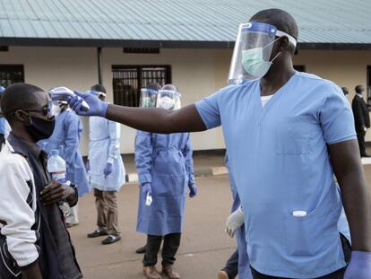 Un sanitario toma la temperatura a un ciudadano de Burundi en el campo de refugiados de Mahama en Ruanda. 