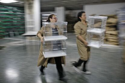 Dos mujeres trasladan urnas en un local electoral de Sevilla.