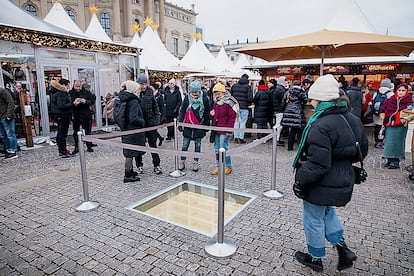 La biblioteca vacía y subterránea del escultor israelí Micha Ullman rodeada por cuatro bolardos para protegerla de los visitantes del mercado navideño en la Bebelplatz, Berlín 16 diciembre 2022.