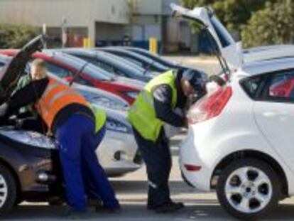 Varios operarios revisan unos Ford Fiesta salidos por la l&iacute;nea de montaje de la factor&iacute;a Ford de Almussafes. 