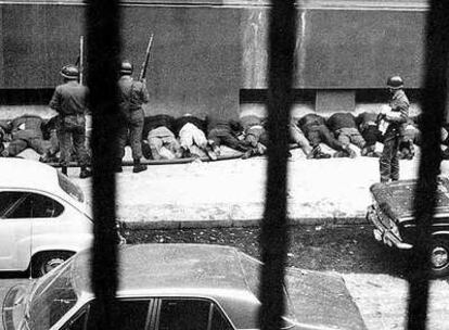 Empleados del palacio presidencial de La Moneda en Santiago de Chile son obligados a arrodillarse contra la pared en una acera tras ser detenidos por soldados leales a Pinochet el 11 de septiembre de 1973. 
Foto: Associated Press