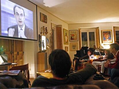 Joaquín Sabina (al fondo, segundo por la izquierda) sigue en su casa el debate entre Zapatero y rajoy acompañado de unos amigos.