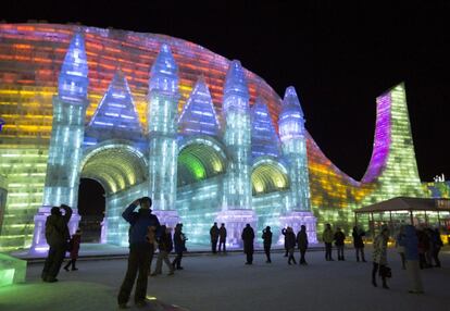 Festival anual de hielo y nieve de Harbin. Visitantes ante una de las coloristas esculturas de hielo.