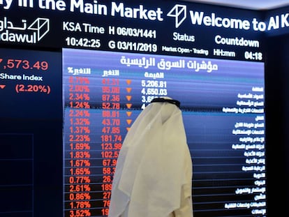 Un saudí pasa ante un monitor con datos de precios del índice Tadawul, en Riad. 
