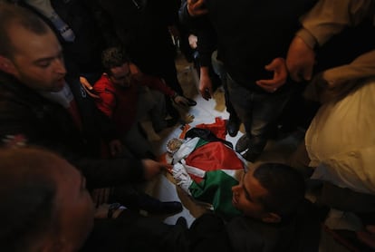 Un grupo de palestinos se reúnen en torno al cuerpo de Muhammad Mubarak, en ​​su casa, antes de su funeral en el campamento de refugiados de Jalazoun cerca de la ciudad cisjordana de Ramala.