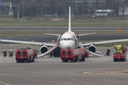 La policía holandesa detiene al pasajero español debajo del ala izquierda del avión, el pasado viernes en Amsterdam.