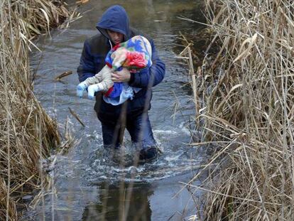 Un kosovar con un beb&eacute; trata de cruzar ilegalmente a Hungr&iacute;a desde Serbia, cerca de Asotthalom, el 6 de febrero.