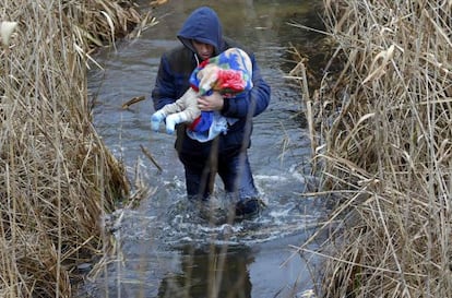 Un kosovar con un bebé trata de cruzar ilegalmente a Hungría desde Serbia, cerca de Asotthalom, el 6 de febrero.