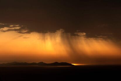 El sol sale tras un banco de nubes en la isla griega de Sifnos. 
