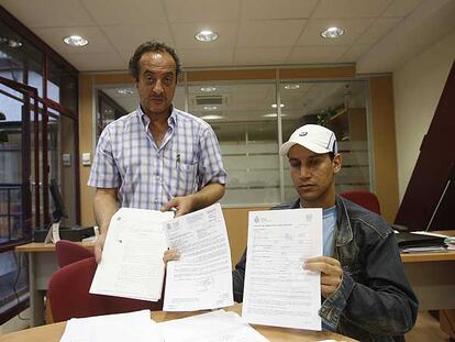 Hassan Aimani, técnico de CC OO, junto a Sahli, que muestra el contrato de trabajo que ha firmado para conseguir papeles.