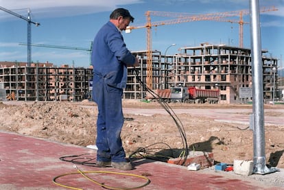 Un obrero trabaja en la instalación del tendido eléctrico de una calle en el PAU de Sanchinarro, en Madrid. La imagen fue tomada el 25 de enero de 2003, cuando ya se habían entregado a sus propietarios las primeras viviendas pero aún faltaban muchas por concluir.