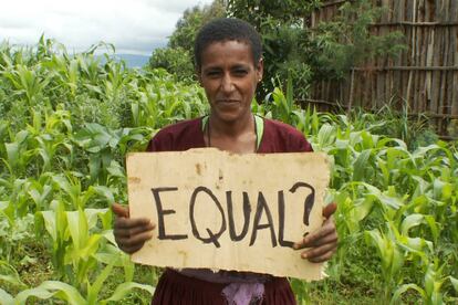 Una granjera de Biresaw, en Etiopía, con un cartel en el que se pregunta: ¿Iguales?