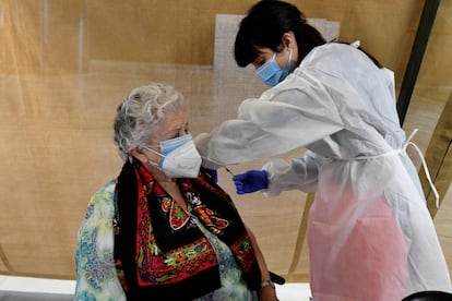 Una empleada sanitaria inocula una dosis de la vacuna contra la covid-19 durante la jornada de vacunación masiva a mayores de 80 años que se realiza este jueves 1 de abril de 2021 en el Palacio de Congresos de León.