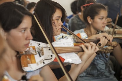 Niñas tocan su instrumento reciclado durante un ensayo de la humilde orquesta juvenil de Paraguay que toca con instrumentos reciclados del vertedero de su barrio.