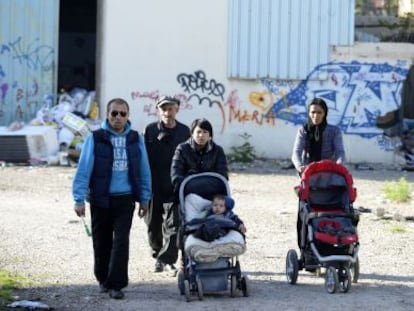 Un grupo de gitanos abandona la factoría incendiada.