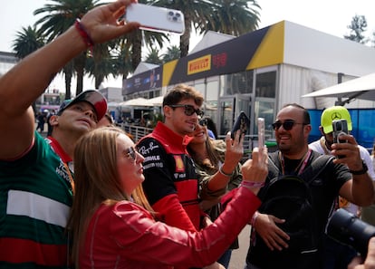 Algunos de los aficionados con entradas VIP se toman una selfie con Charles Leclerc, piloto de Ferrari.