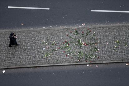 Una mujer fotografía un altar improvisado, cerca del mercadillo navideño de Berlín donde ha tenido lugar el atentado.