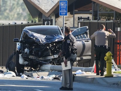 Dos agentes de policía inspeccionan el lugar del siniestro, junto al vehículo destrozado que golpeó a los reclutas del condado de Los Ángeles.