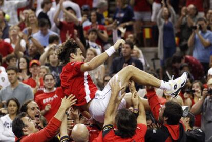 Ferrer is hoisted aloft by the Spain team after his four-set win over Mardy Fish.