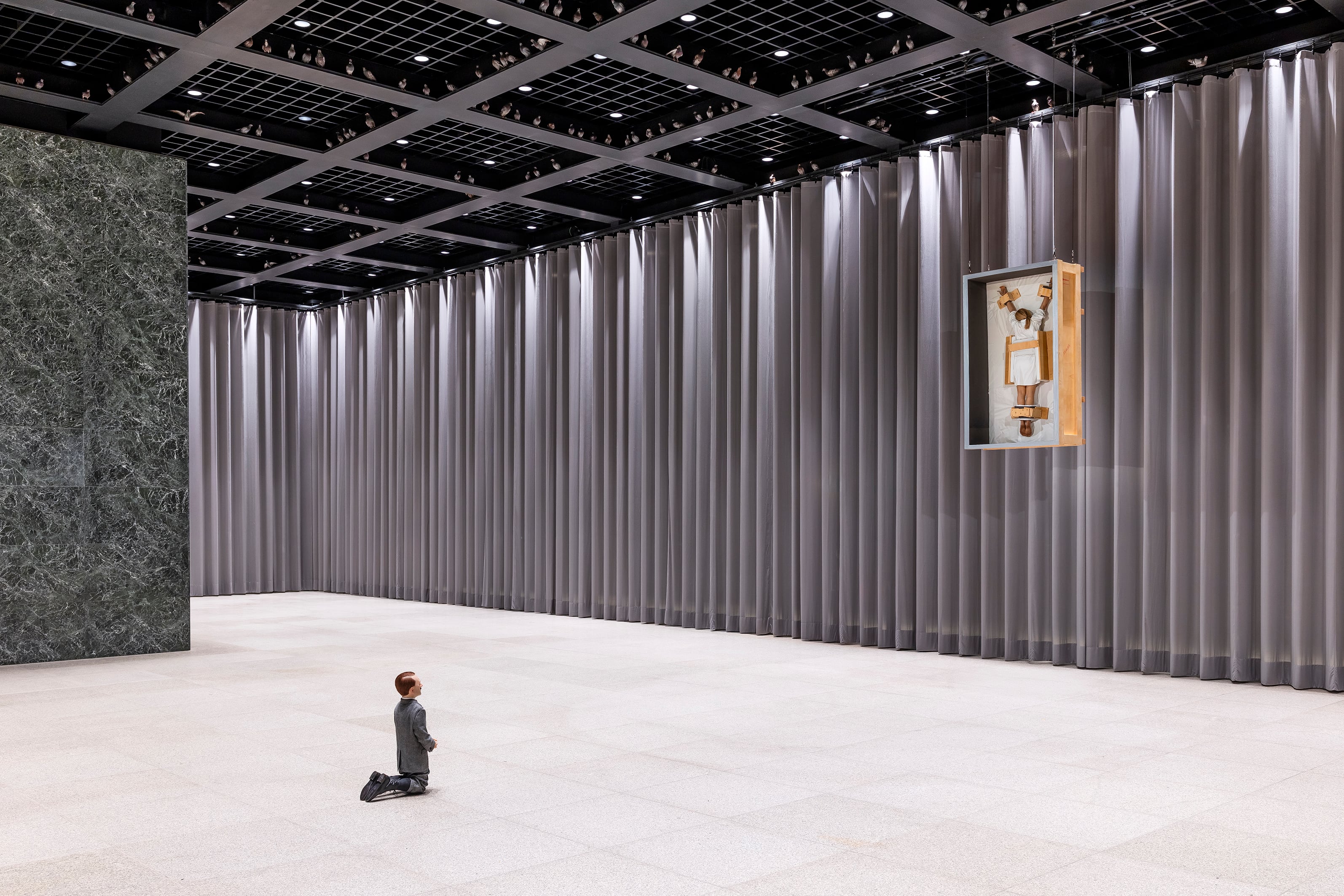 Las obras 'Him' (2001), que muestra a Hitler arrodillado, y 'Dawn' (2007), una crucifixión con una mujer torturada en el centro, en las salas de la Neue Nationalgalerie de Berlín.
