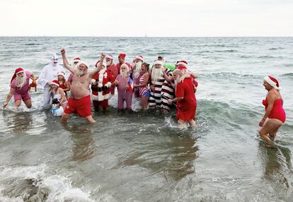 Asistentes posan para una foto durante el baño en el mar, que forma parte de los eventos del congreso de Santa Claus.