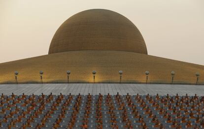 Monjes budistas tailandeses rezan en el templo de Wat Dhammakaya para participar en las ceremonias del Día de Makha Bucha, en Pathum Thani (Tailandia).